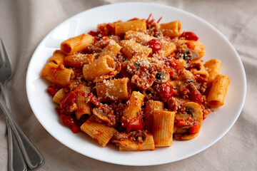 Homemade Italian Sausage and Mushroom Ragu Rigatoni Pasta with Cheese on a Plate, side view.