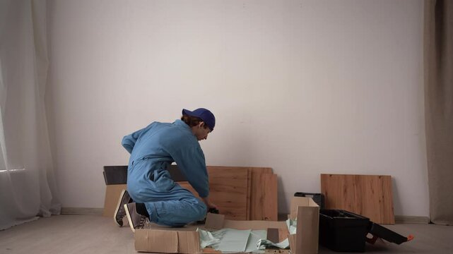 Furniture assembly concept. Repairman unpacking furniture. Moving concept. Furniture assembler