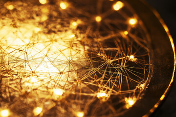 Close-up view of a Bitcoin coin showcasing intricate design with reflective gold surface under bright light