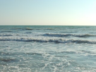sea ​​ebb visible from the beach, wave rollback into the sea, beautiful sea surface on a sunny day, photo of the seashore with ebb water from a sandy beach