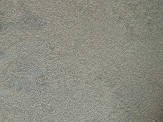 dusty surface close-up full frame, white fluffy dust on dark background, household or construction powdery fine dust, uneven layer of dust on flat space