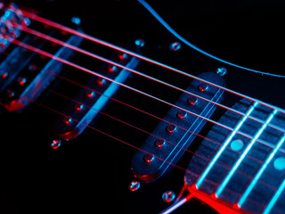 Electric guitar strings close up. Musical instrument details. Concert color contrast lighting. Six-string guitar during performance. Bright colors on dark background. Cinematic light. Copy space