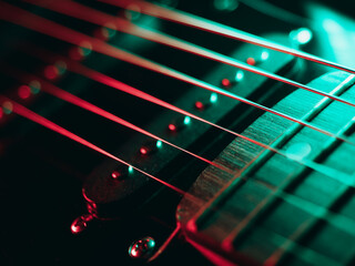Electric guitar strings close up. Musical instrument details. Concert color contrast lighting. Six-string guitar during performance. Bright colors on dark background. Cinematic light. Copy space
