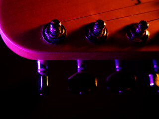 Electric guitar strings close up. Musical instrument details. Concert color contrast lighting. Six-string guitar during performance. Bright colors on dark background. Cinematic light. Copy space