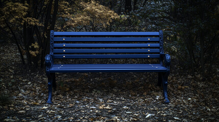 Blue bench in the dark forest. Dark blue wooden park or garden chair with rusted iron rivets on an overgrown background.