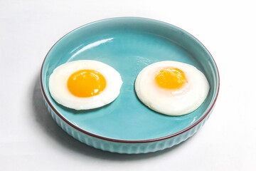 a plate of fried eggs on a white background