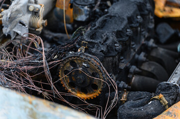 A close-up of the burnt-out engine compartment of a car.
