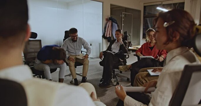 A diverse team of business professionals collaborates in a modern office, engaging in a productive and enjoyable meeting.