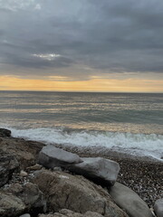 Landscape of sea and rocky beach at sunset