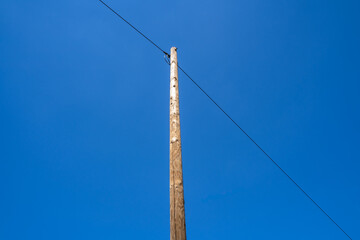 Obraz premium Wooden pole with a telephone wire