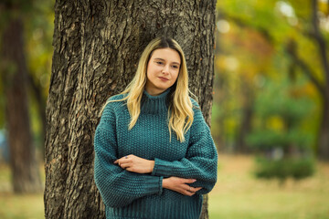 Portrait of beautiful blonde young woman in green sweater
