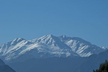 Fototapeta premium Snowy mountains on a sunny day. Mountain peak against blue sky. Antalya, Türkiye