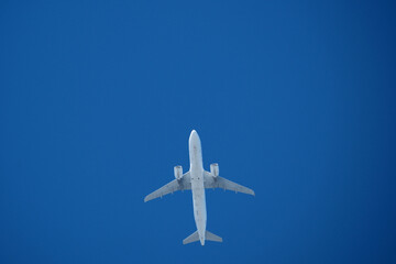 Jet airplane flying overhead in clear blue sky. Airplane in the blue sky.