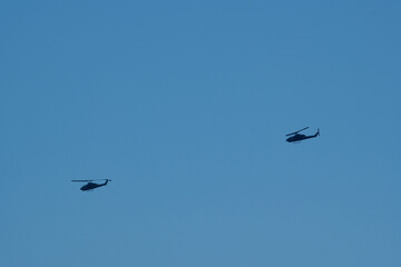 Military helicopters flying in the blue sky. 