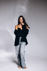 Fototapeta premium Young woman wearing black jacket posing in studio