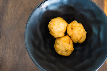 Deep fried shrimp balls on black bowl