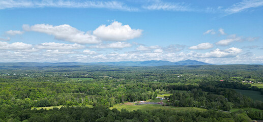 Obraz premium view of catskill mountains at sunset (wide angle aerial mountain vista in catskills hudson valley slide mountain wilderness hiking area) dramatic huge puffy clouds sky cloud formation farm rural area