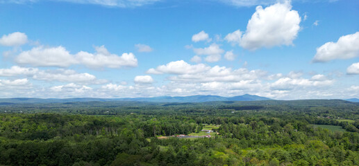 view of catskill mountains at sunset (wide angle aerial mountain vista in catskills hudson valley slide mountain wilderness hiking area) dramatic huge puffy clouds sky cloud formation farm rural area