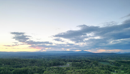 view of catskill mountains at sunset (wide angle aerial mountain vista in catskills hudson valley slide mountain wilderness hiking area) dramatic huge puffy clouds sky cloud formation farm rural area