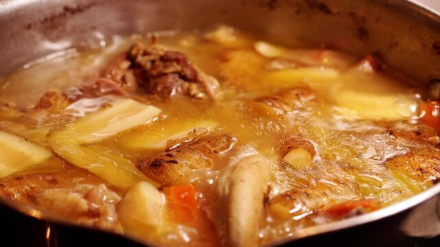 cuicine fran&ccedil;aise avec la cuisson de l&egrave;gumes avec langue de veau, et l&eacute;gumes vari&eacute;s du jardin, dans une grande casserole en inox, avec zoom arri&egrave;re de cam&eacute;ra