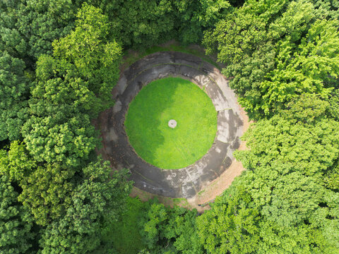 overgrown concrete circles round paths at old model aircraft field in new york city (flushing meadows corona forest park) landing takeoff area drone flight looking down cement grass strip green