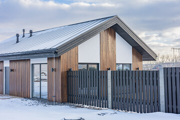 Fototapeta premium Modern house features a minimalist aesthetic with clean lines, simple forms, and a focus on functionality. The use of natural materials like wood and stone adds warmth and texture, 