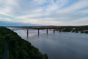 Fototapeta premium view of walkway over the hudson at sunset (tall former railroad bridge over the hudson river in poughkeepsie new york) part of empire state trail and hudson valley rail cycling pedestrian path