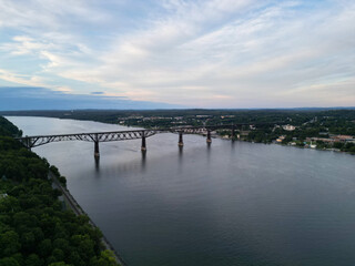 Fototapeta premium view of walkway over the hudson at sunset (tall former railroad bridge over the hudson river in poughkeepsie new york) part of empire state trail and hudson valley rail cycling pedestrian path