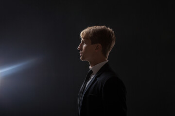 A young businessman in profile. A thoughtful man in a business suit looks into the distance towards...