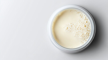 Creamy texture in round container, showcasing smooth surface with bubbles. Ideal for skincare or cosmetic products