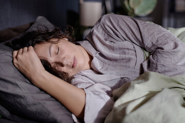 Medium close up of adult woman taking nap in comfortable bed