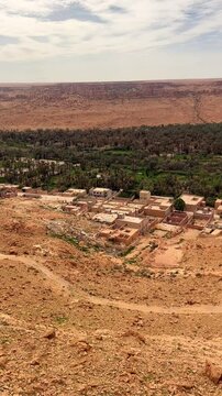 Green oasis in Atlas Mountains with cliffs and rocks. Meski, Morocco. Vertical. Panorama