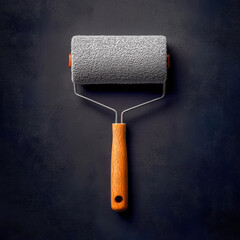 Obraz premium Paint roller with wooden handle on dark background representing home improvement and diy projects