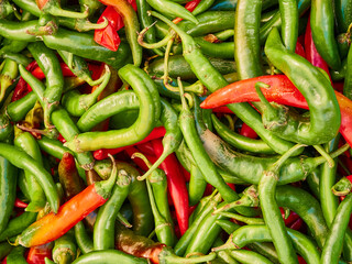 Red and green hot chili peppers on display at a farmers market