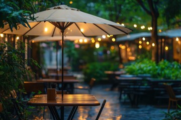 Obraz premium Cozy outdoor dining area adorned with lights and umbrellas on a rainy evening