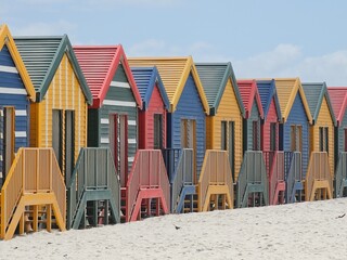 Vibrant beach huts stand in a row on muizenberg beach, cape town, south africa, creating a picturesque scene