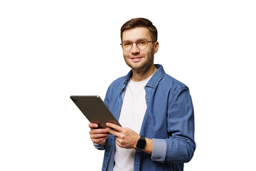 Young man in casual attire holds a tablet while smiling against a white background in a bright indoor setting