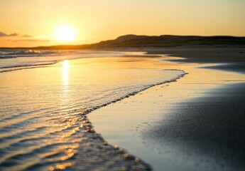 Obraz premium The sun is setting over the ocean, casting a warm glow on the water