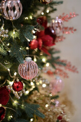 Christmas decoration details on tree branch with bulb ornaments, flower arrangement on twig