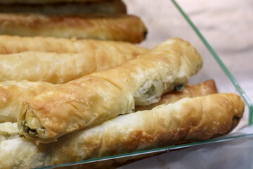 
Several long, golden brown, delicious patties folded from thin dough and filled with some green filling.