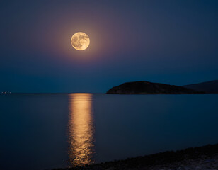 blue sky in the night with full moon over water