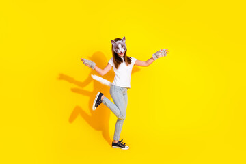 Young girl in cat disguise against vibrant yellow backdrop showcasing playful youthful energy