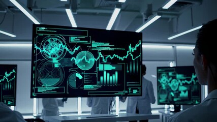 Research team analyzes data trends in high-tech laboratory with digital displays