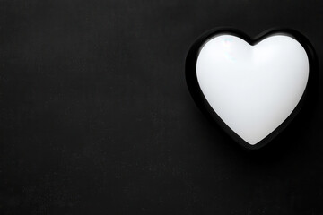 Obraz premium Heart shaped glowing frame on black background, creating minimalist and elegant design Blank background space for text