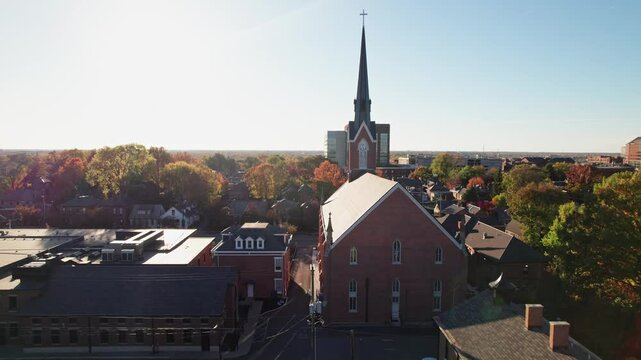 Red brick classic and vintage church with steeple in historic district German Village outside Columbus, Ohio for Christian and Catholic religious gatherings, sermons, and ceremony along High Street