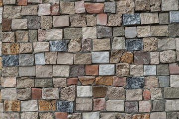 Beige and gray stone mosaic covering, close-up.