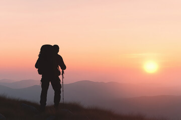 A man with a backpack is standing on a mountain top at sunset