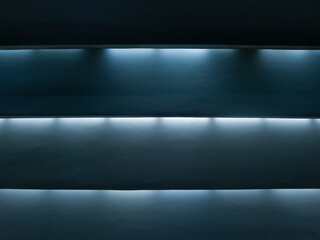 Cold cornice lighting. Horizontal blinds with light shining through the slats, creating a striped pattern of light and shadow. © Dmytro