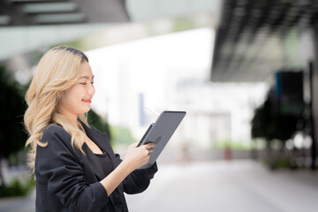 Confident businesswoman holding a tablet and stylus, emphasizing precision and adaptability in a contemporary workspace, blending style and functionality.