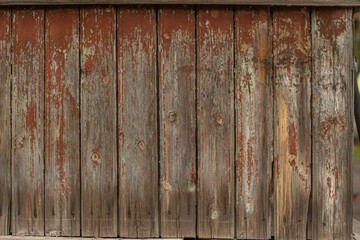 Wall made of an old wooden boards with peeling brown paint.
